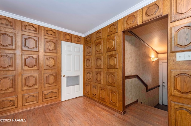 foyer entrance with crown molding and light wood-type flooring