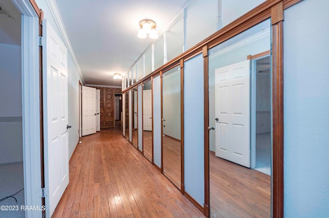 hall with ornamental molding and light wood-type flooring