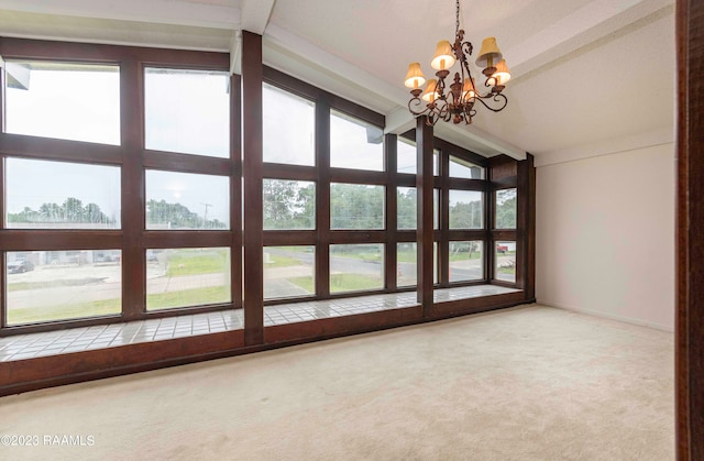 spare room with plenty of natural light, carpet floors, and a chandelier