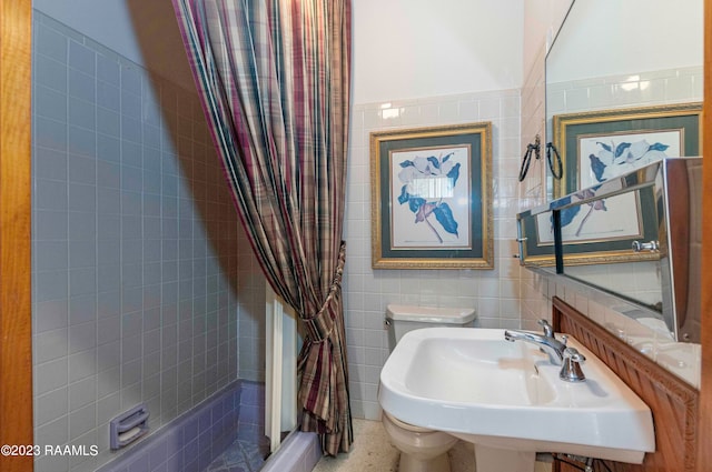 bathroom with tile walls, toilet, sink, and a shower with curtain