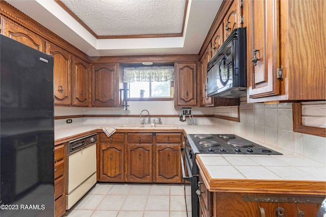 kitchen with tasteful backsplash, tile countertops, black appliances, sink, and light tile flooring