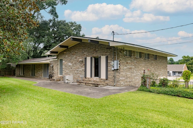 rear view of house featuring a lawn and a patio