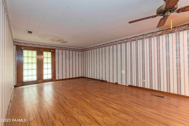 empty room featuring french doors, ceiling fan, and light wood-type flooring