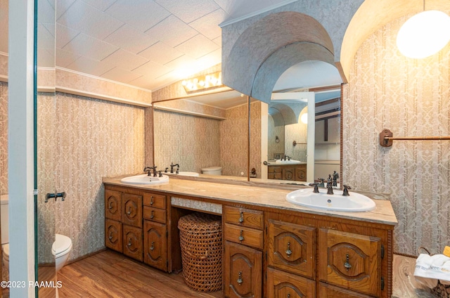 bathroom with hardwood / wood-style floors, oversized vanity, toilet, and dual sinks