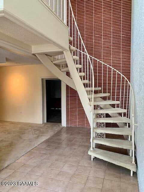 stairs with a high ceiling and light tile floors