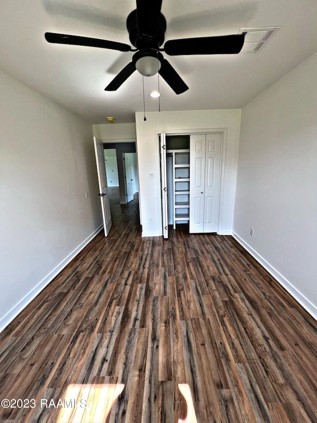 unfurnished bedroom featuring a closet, ceiling fan, and dark wood-type flooring