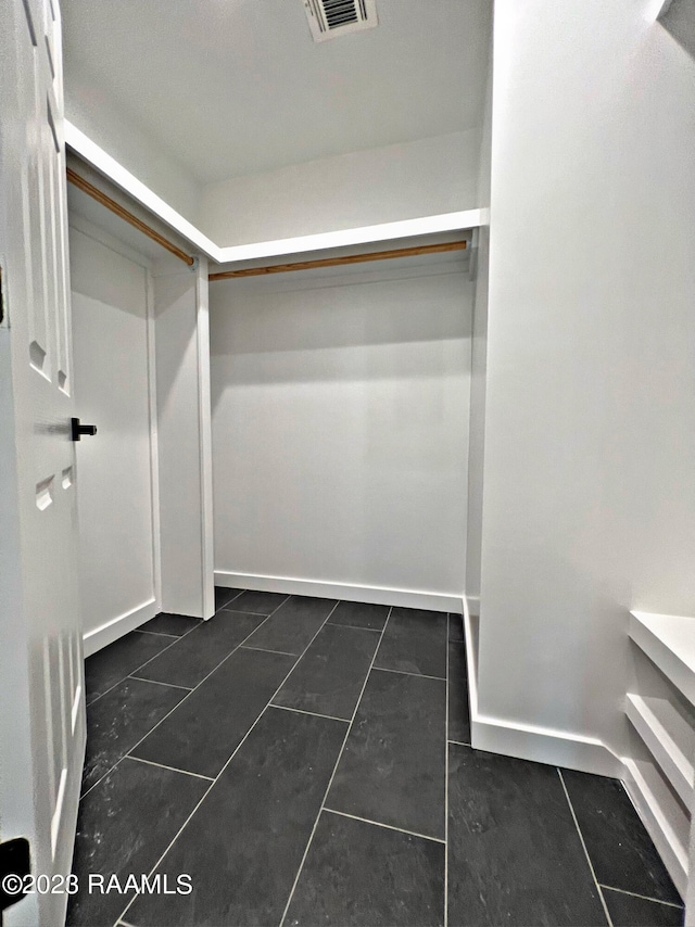 spacious closet featuring dark tile patterned floors