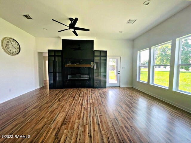 unfurnished living room with ceiling fan and dark hardwood / wood-style flooring