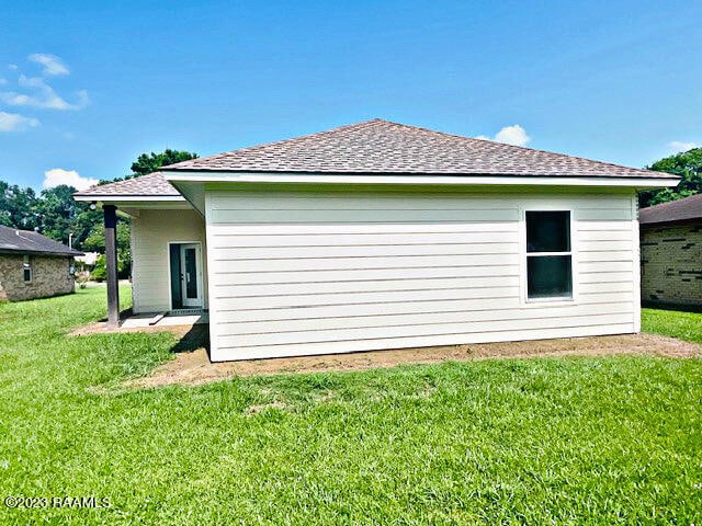 view of side of home with a lawn