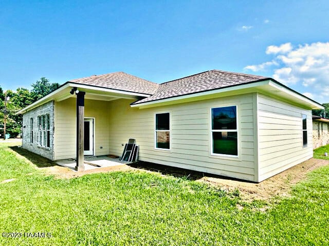 rear view of house with a yard and a patio area