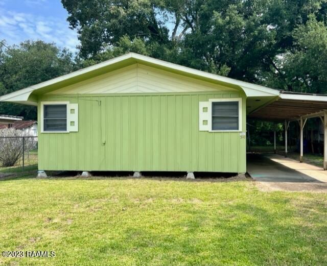 exterior space with a carport and a lawn