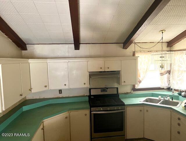 kitchen with beam ceiling, stainless steel range with gas cooktop, and sink