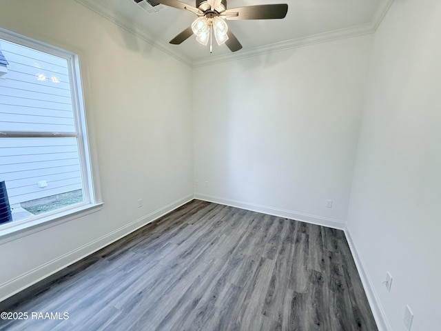 unfurnished room with crown molding, ceiling fan, visible vents, wood finished floors, and baseboards