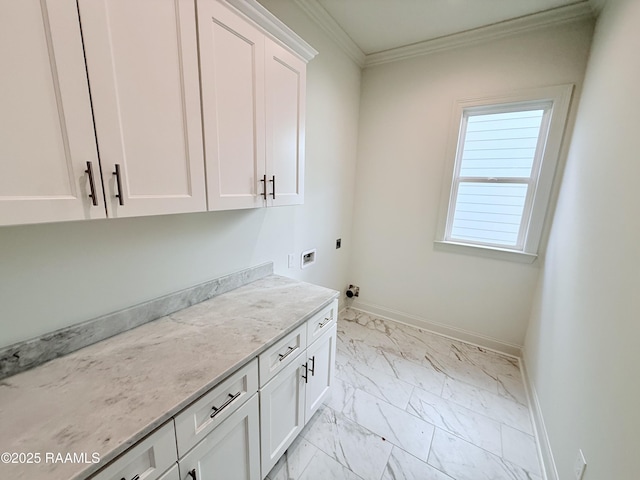 washroom featuring electric dryer hookup, ornamental molding, marble finish floor, baseboards, and cabinet space
