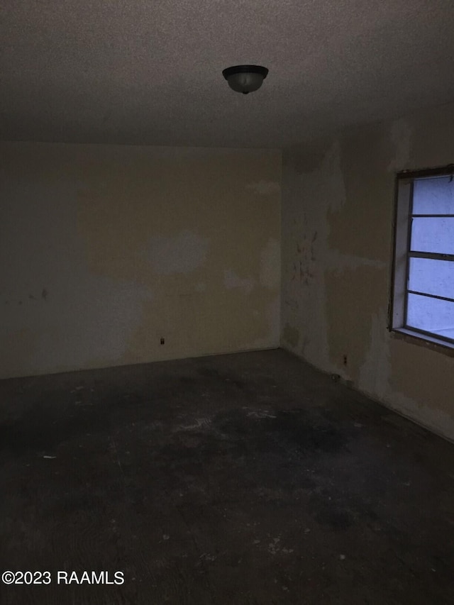 unfurnished room with a textured ceiling