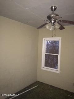 carpeted spare room featuring ceiling fan