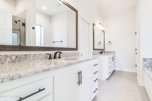 bathroom featuring a sink, two vanities, a shower stall, and tile patterned floors