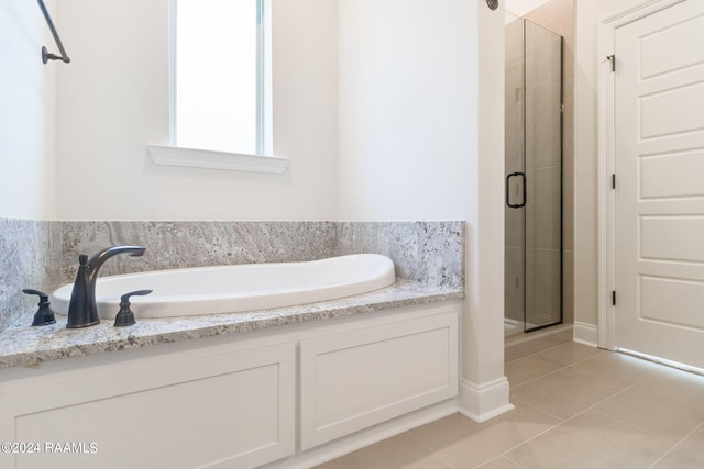 bathroom featuring tile patterned floors, a stall shower, and a bath