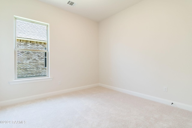 unfurnished room with baseboards, visible vents, and light carpet