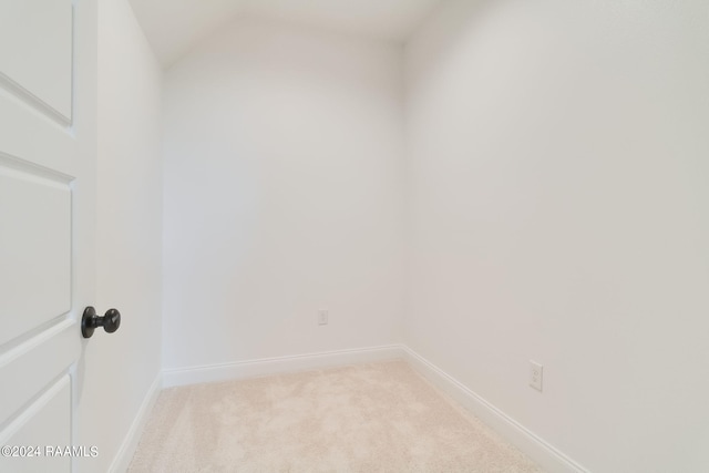 spare room featuring baseboards and light carpet