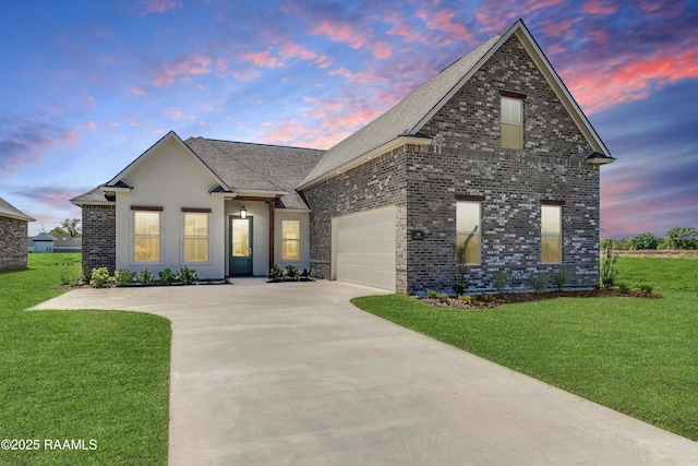 view of front facade featuring a front lawn, concrete driveway, brick siding, and an attached garage