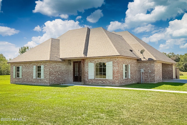 rear view of property featuring a garage and a yard