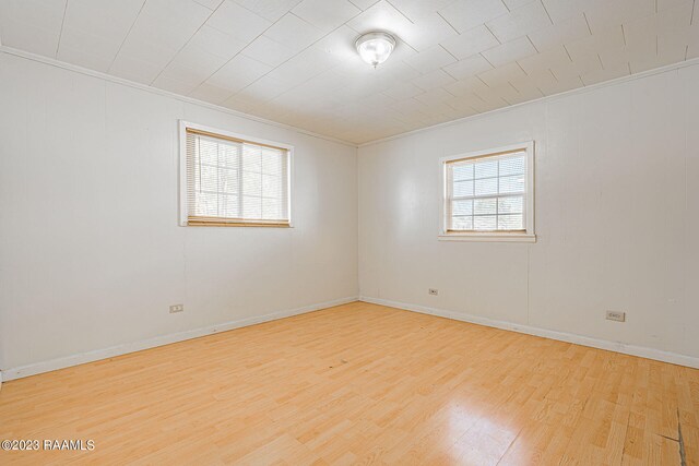 unfurnished room with ornamental molding and light hardwood / wood-style floors