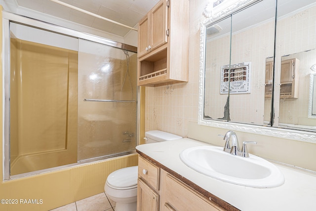 full bathroom with toilet, shower / bath combination with glass door, vanity with extensive cabinet space, tile walls, and tile flooring