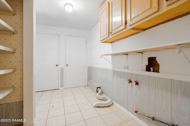 washroom featuring light tile flooring and cabinets