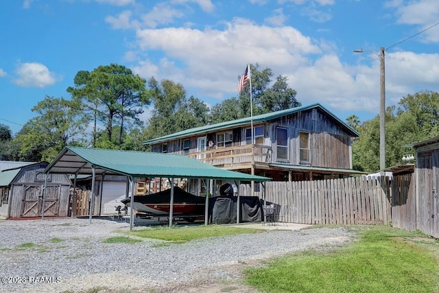 view of front facade with a carport and a storage shed