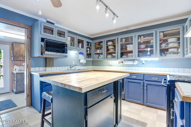 kitchen with a center island, a kitchen bar, wooden counters, and blue cabinets