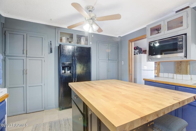 kitchen with wooden counters, white fridge, light tile patterned floors, ceiling fan, and black fridge with ice dispenser