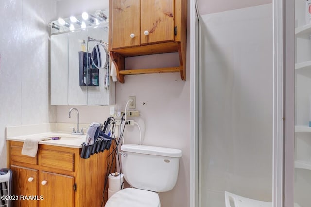 bathroom featuring an enclosed shower, vanity, and toilet