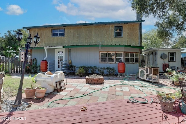 rear view of property with a patio area and an outdoor fire pit