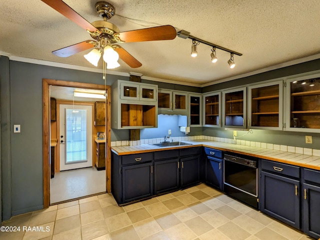 kitchen featuring sink, a textured ceiling, tile counters, and dishwasher