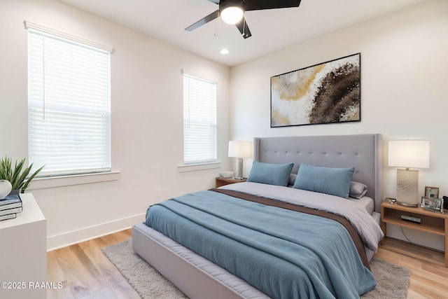 bedroom with multiple windows, ceiling fan, and light wood-type flooring