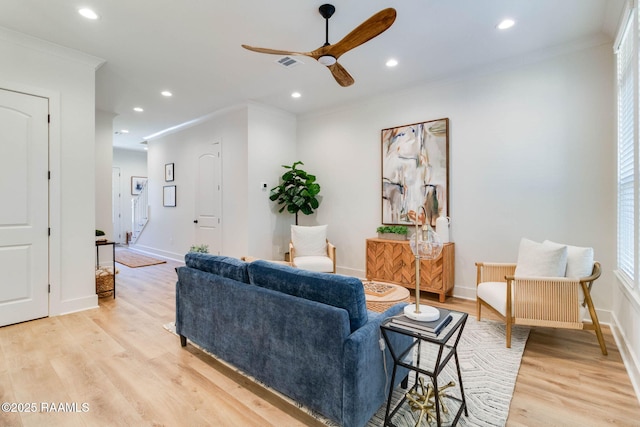 living room featuring light wood-type flooring, ceiling fan, and ornamental molding