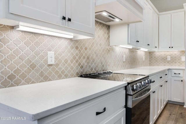 kitchen with white cabinetry, stainless steel electric range oven, backsplash, custom exhaust hood, and light wood-type flooring