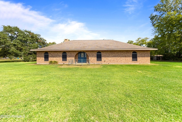 rear view of property with a lawn