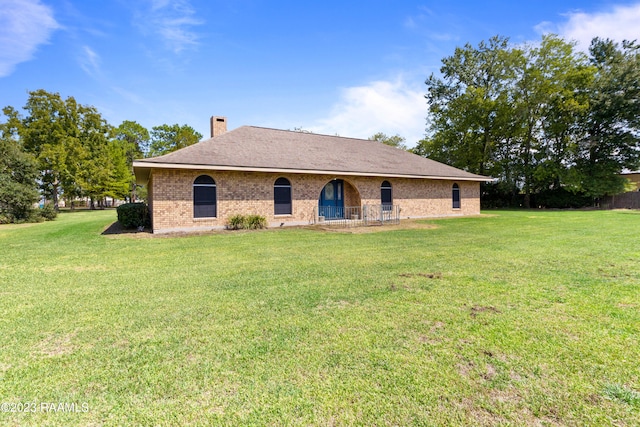 back of house featuring a lawn