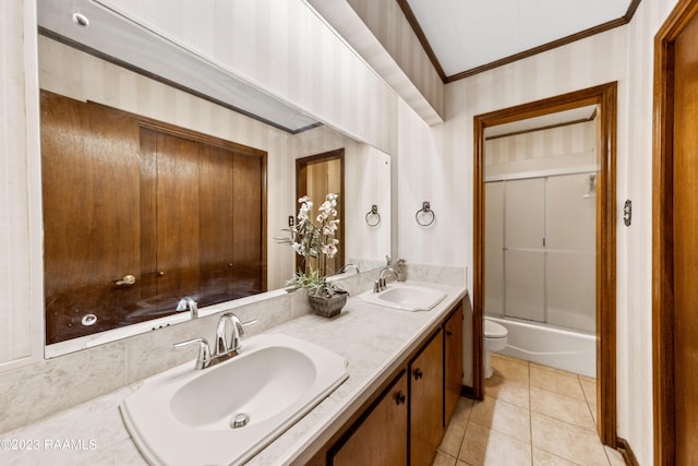 full bathroom with crown molding, bath / shower combo with glass door, vanity, tile patterned floors, and toilet