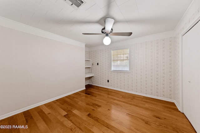 unfurnished bedroom featuring hardwood / wood-style flooring, ornamental molding, and ceiling fan