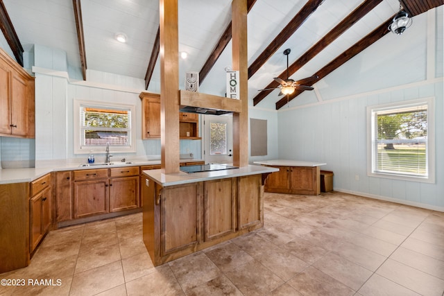 kitchen featuring black electric cooktop, sink, plenty of natural light, and a center island