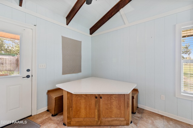 interior space with light tile patterned flooring and lofted ceiling with beams