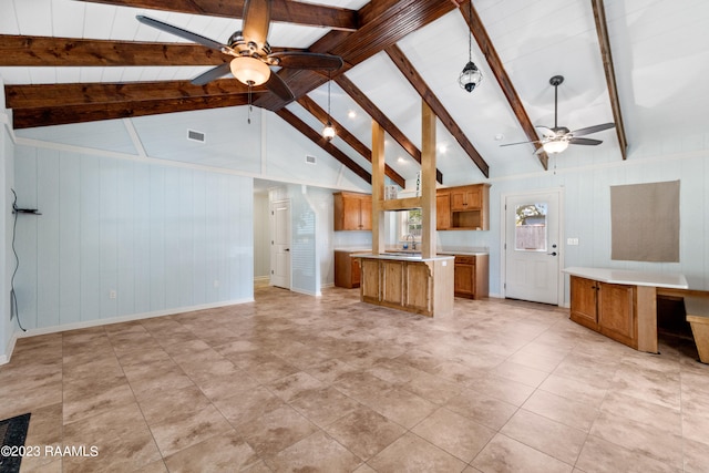 unfurnished living room featuring ceiling fan, built in desk, and vaulted ceiling with beams