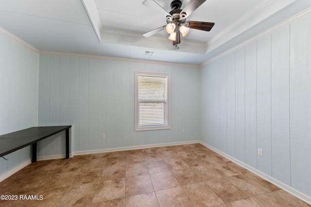 spare room featuring a raised ceiling, crown molding, light tile patterned floors, and ceiling fan