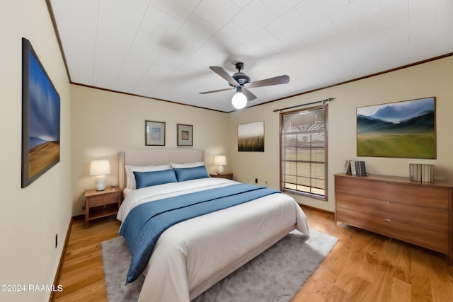 bedroom with crown molding, ceiling fan, and light wood-type flooring