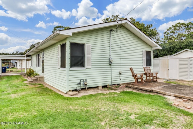 rear view of house with a yard, a patio area, and a shed