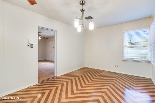 empty room featuring light parquet floors and ceiling fan with notable chandelier