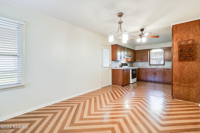 kitchen featuring decorative light fixtures, light parquet floors, backsplash, sink, and white range oven